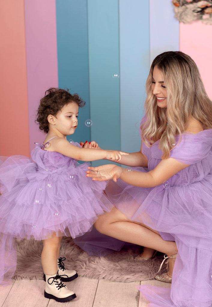 Baby Fairytale Purple Dress is a short dress made with tulle.The baby dress is perfect for a special event. It has an open back with adjustable lacing. The dress back has a big bow to make it stand out. The same dress is available for adults, perfect for Mommy& Baby Dress. It is available in various colors.