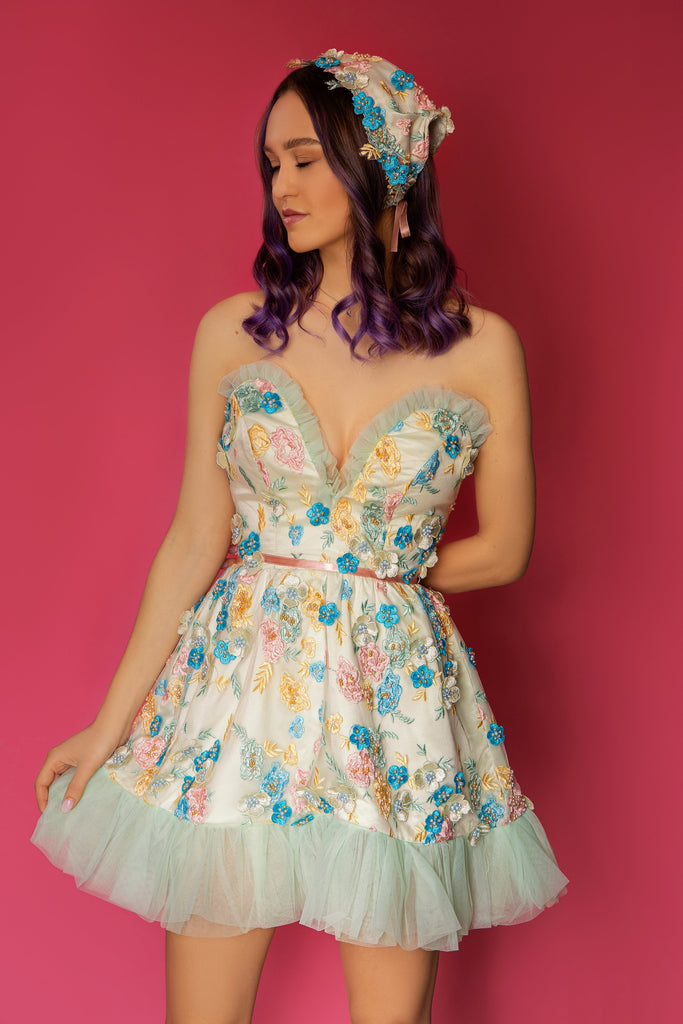  Our iconic Blair corset mini dress a mix of sunny garden floral embroidered. This elegant mini dress has a sweetheart matching scarf with floral appliqués. Open back with adjustable lacing. This elegant mini dress has a sweetheart matching scarf.