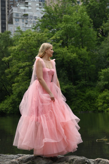Our signature Emma Pink Long Dress is a must-have from our collection. The pink color dress is unique. The upper corset and the lower tulle make the dress magical. The fabric for the upper corset is with straight lines so that it makes the dress special. Elongated functional ties are fastened into bows at the shoulders with adjustable laces front. Zipper closure at center back. Slip it on for a casual hang or dressed up for an evening under twinkle light.